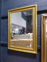 Gilt framed and beveled rectangular wall mirror