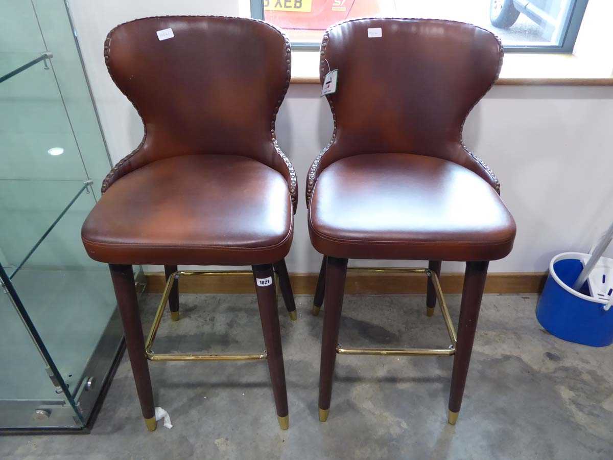 Modern pair of brown leatherette upholstered bar stools with brass studded detail