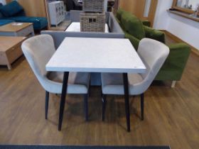Modern grey bistro table on black tapered supports with 2 beige upholstered dining chairs
