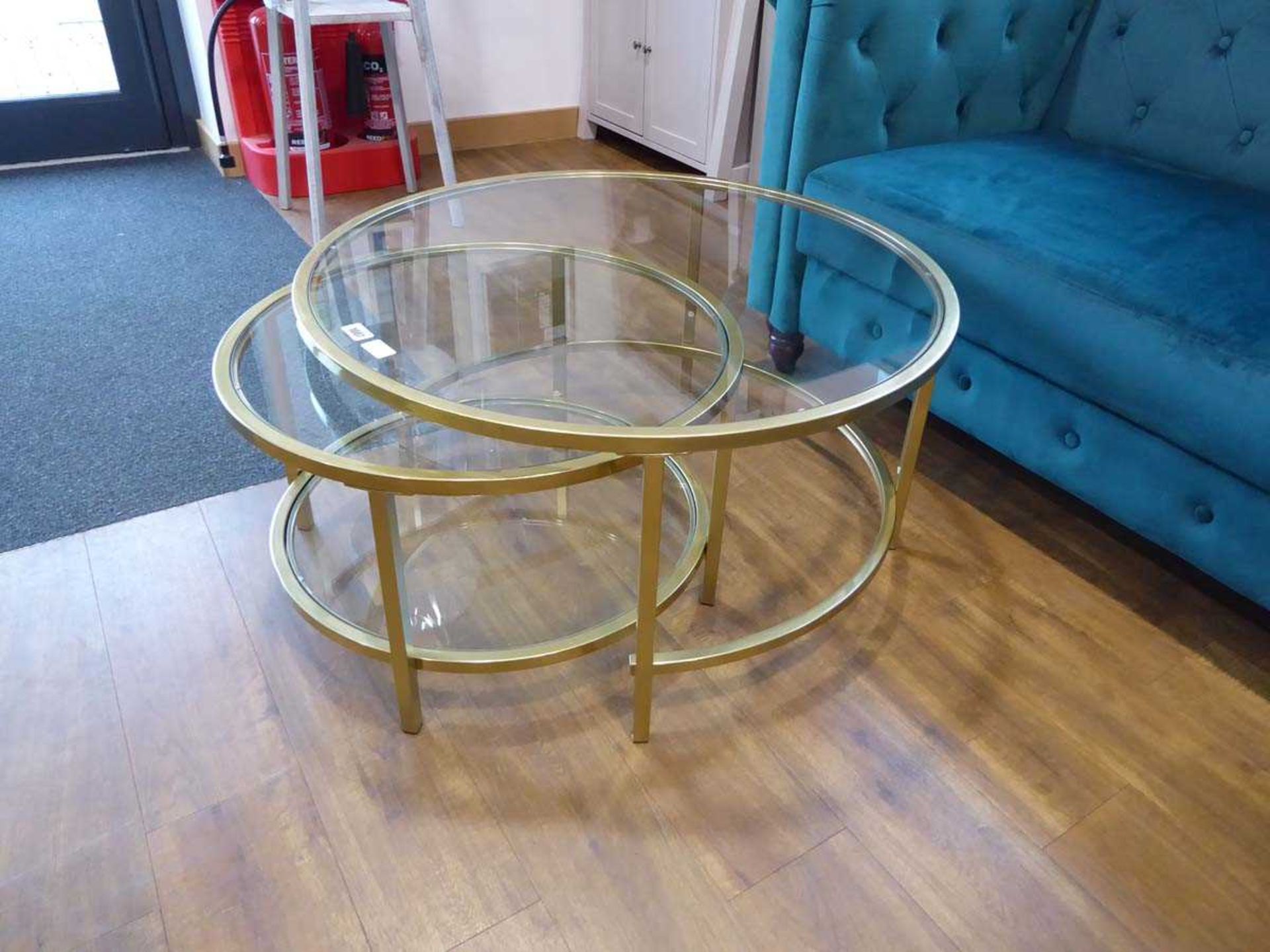 Modern nesting pair of brass finish circular glass topped tables