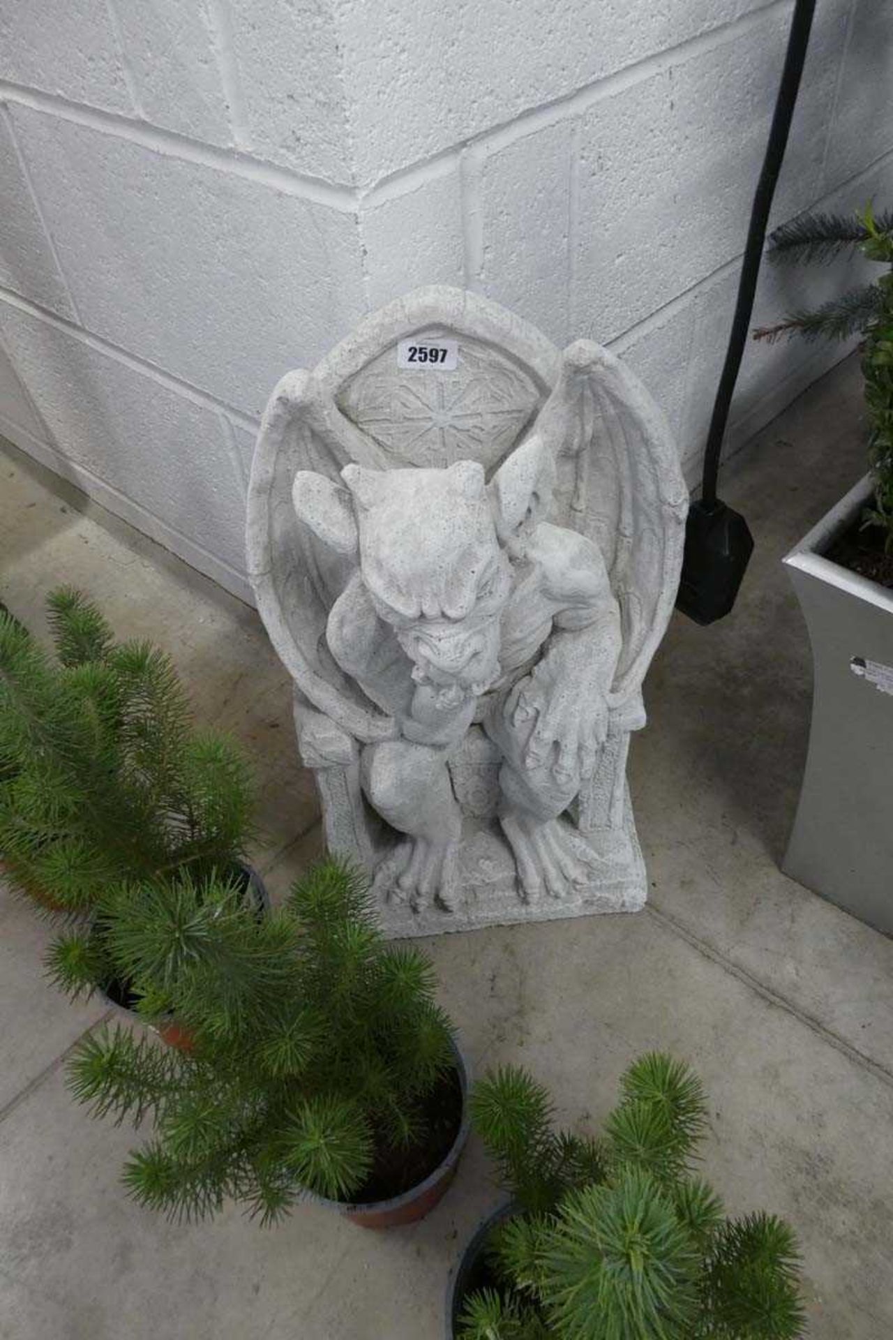 Concrete gargoyle sitting on throne