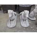 Pair of laying concrete dogs