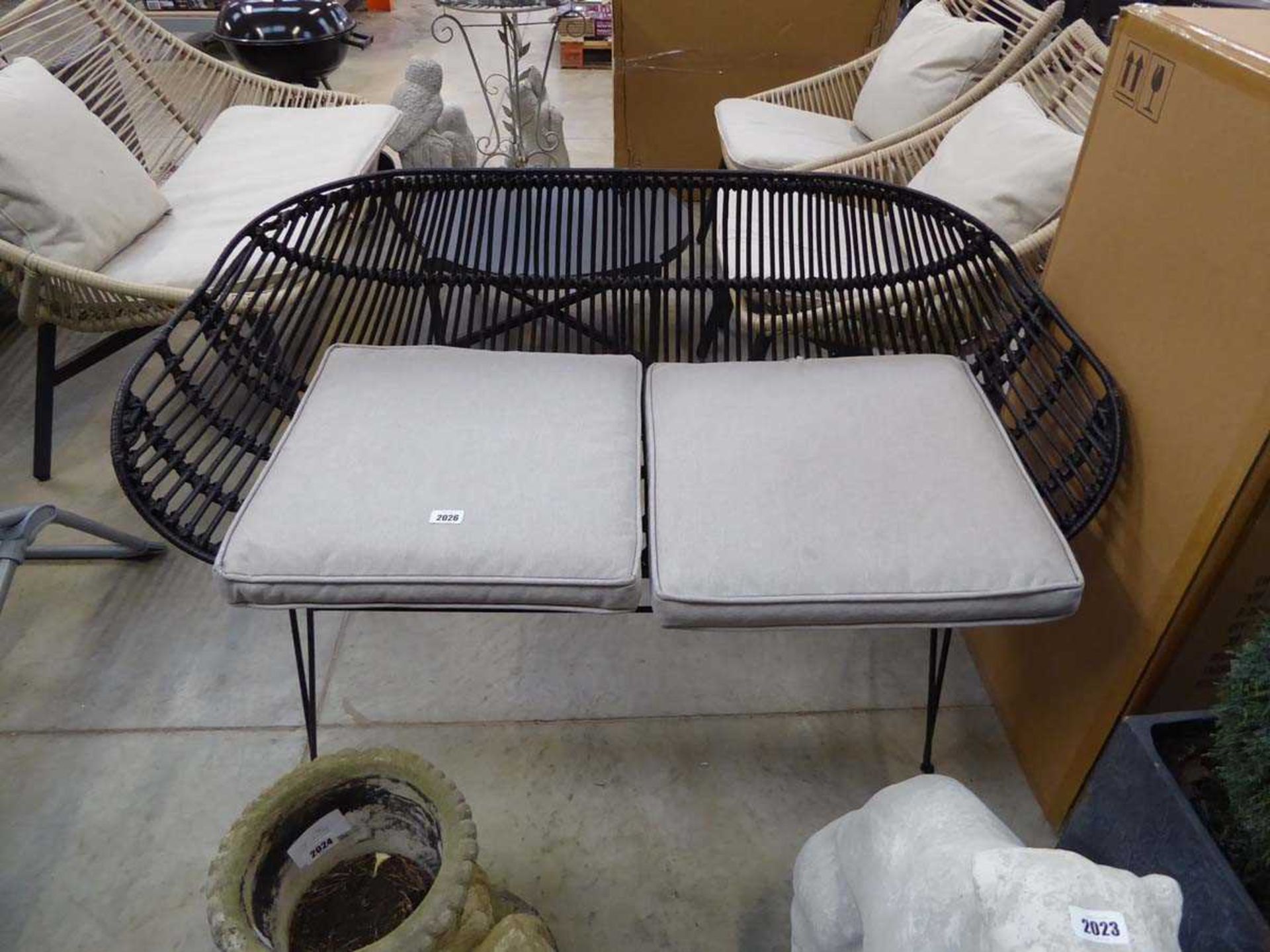 A black 2 seater garden bench with cushions