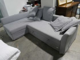 Grey upholstered IKEA L-shaped corner sofa system with ottoman storage