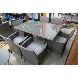 Grey rattan 7 piece outdoor garden dining set comprising a rectangular glass top garden table with 6