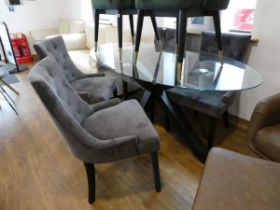 Modern oval glass topped dining table on black crisscross base with 4 grey button backed upholstered