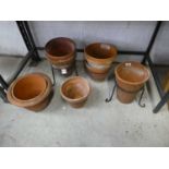 Selection of mixed sized terracotta garden pots with 2 pot stands