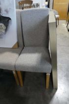 Natural coloured upholstered high back dining chair on light oak supports