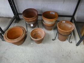 Selection of mixed sized terracotta garden pots with 2 pot stands