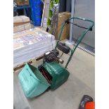 Green petrol powered cylinder mower with grass box