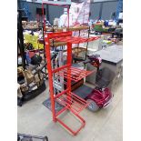 Three shelved red metal rack