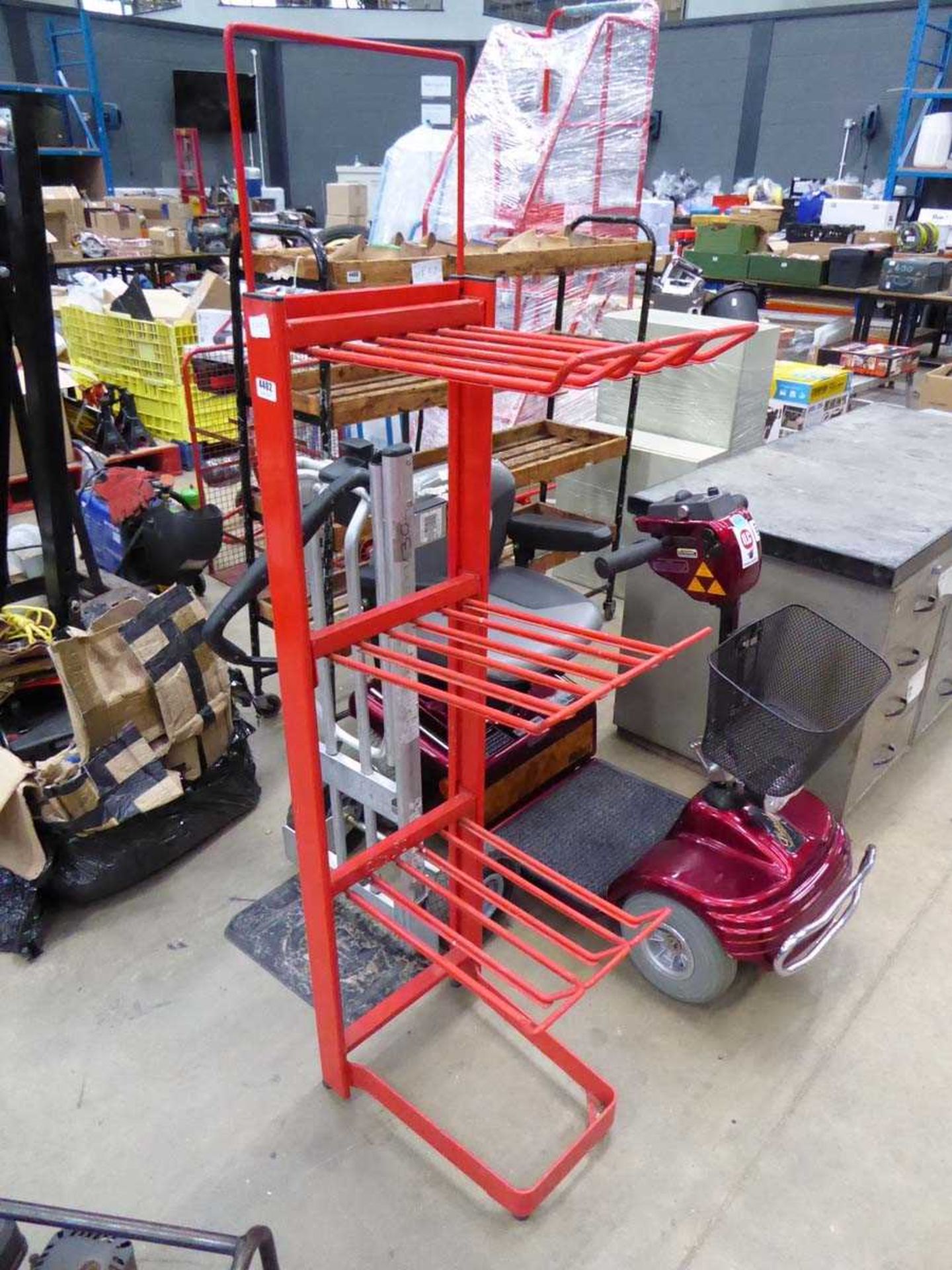 Three shelved red metal rack