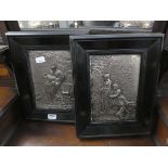 Two metal wall hangings of classical figures in garden