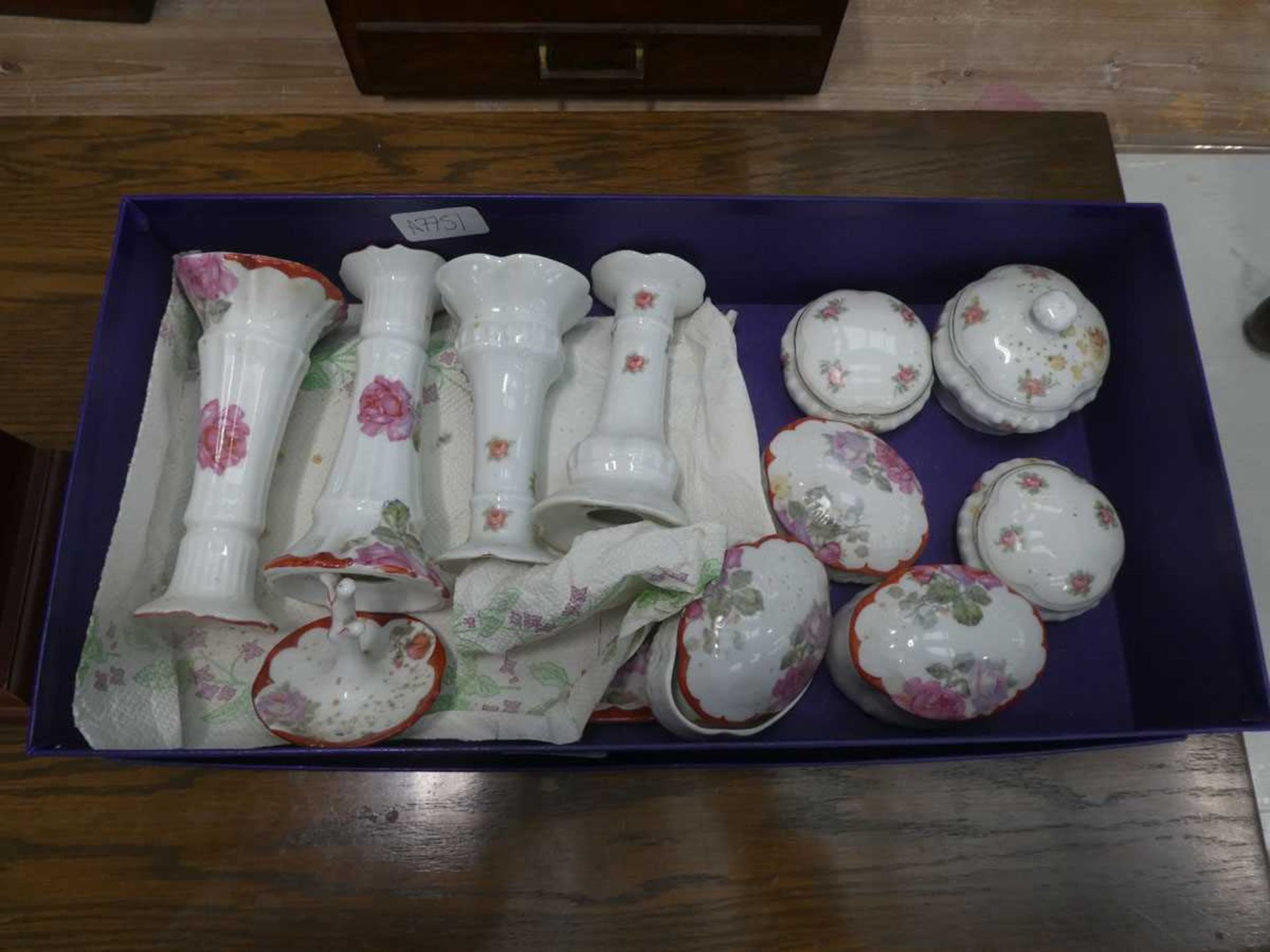 Box containing rose pattern candlesticks and pill boxes