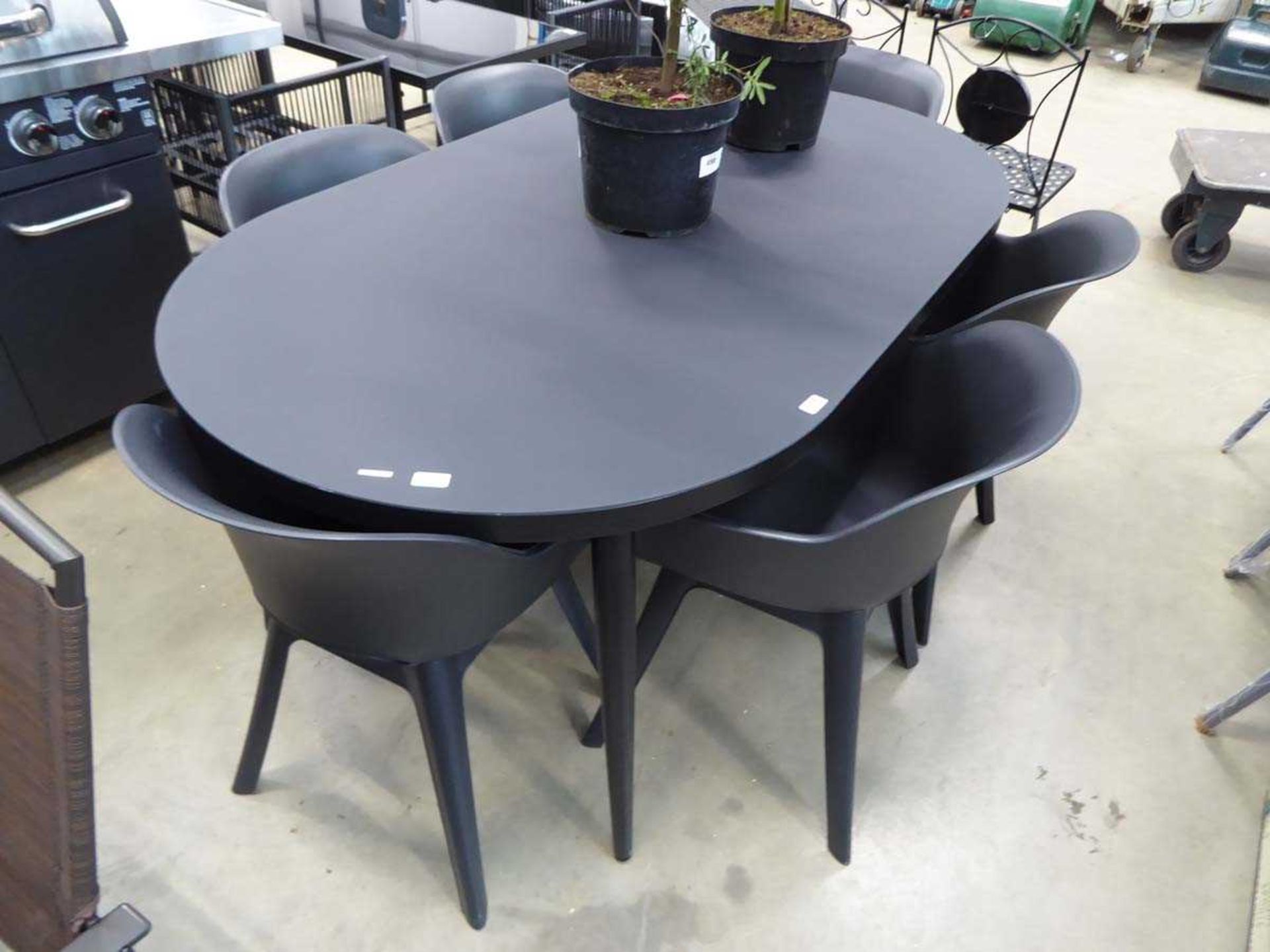 Metal frame glass topped garden table with six plastic chairs