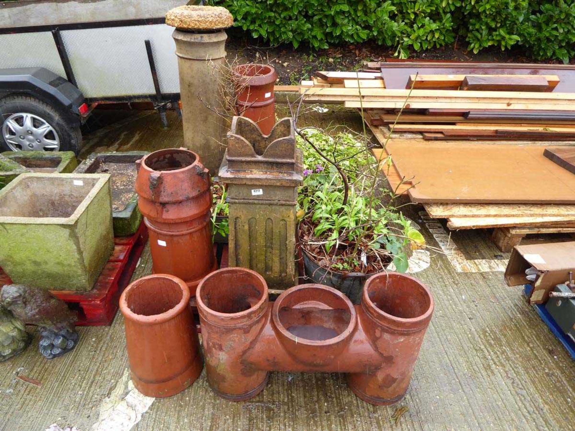 Pallet containing terracotta chimney pots and three galvanised baths with plants