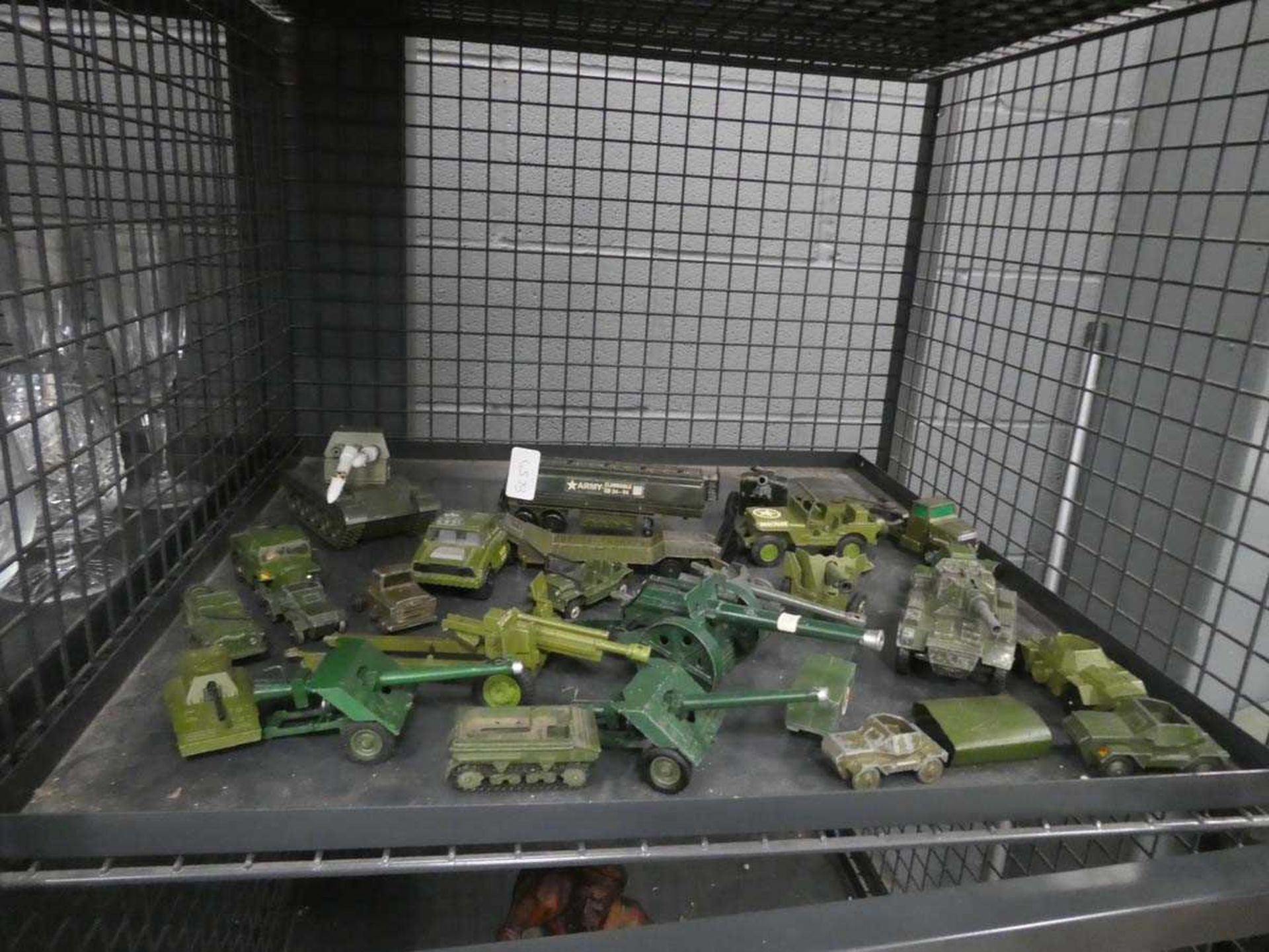 Cage containing diecast military vehicles and artillery