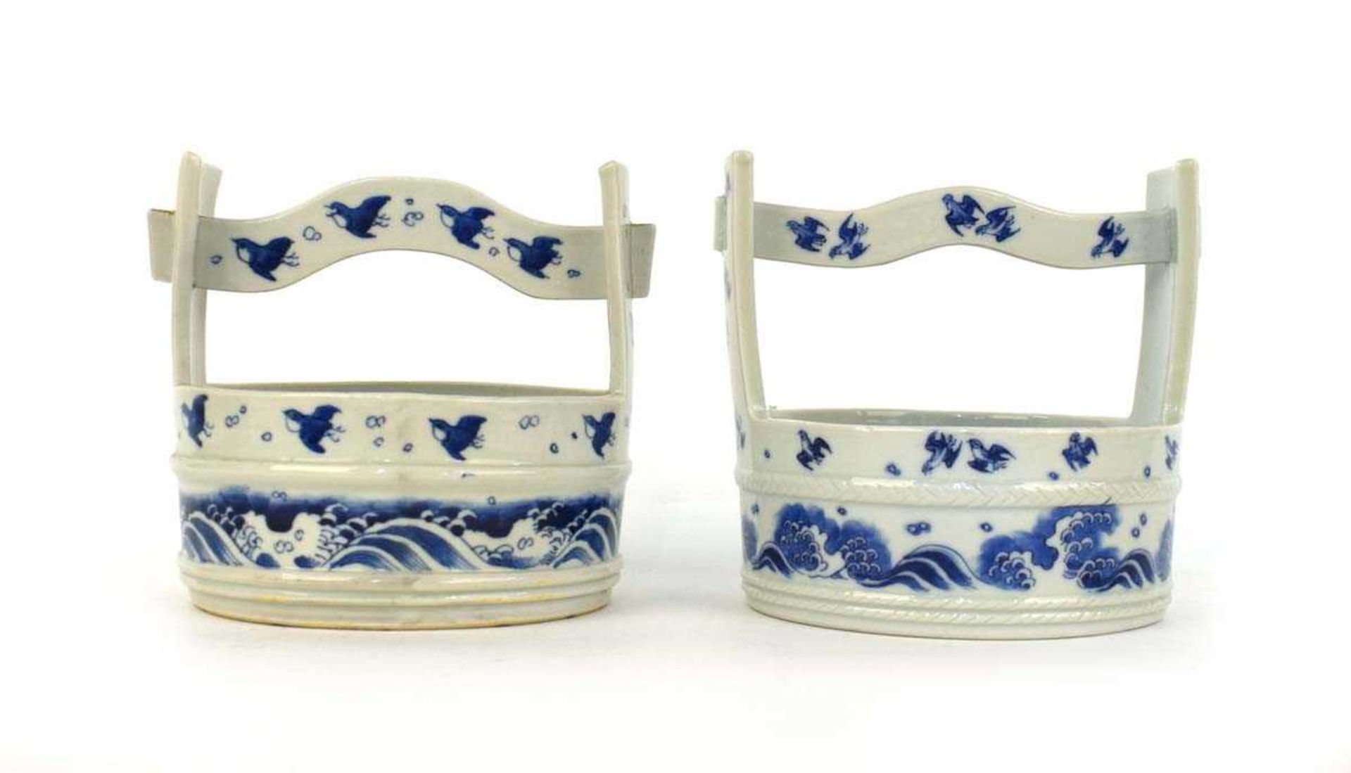 A near pair of Japanese blue and white planters in the form of water carriers, each decorated with
