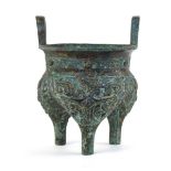 A Chinese green patinated bronze incense burner of archaic form, the triform base decorated with