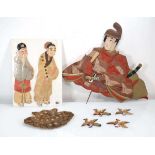 A padded fabric wall hanging modelled as a seated warrior, w. 50 cm, a further pair of figures and