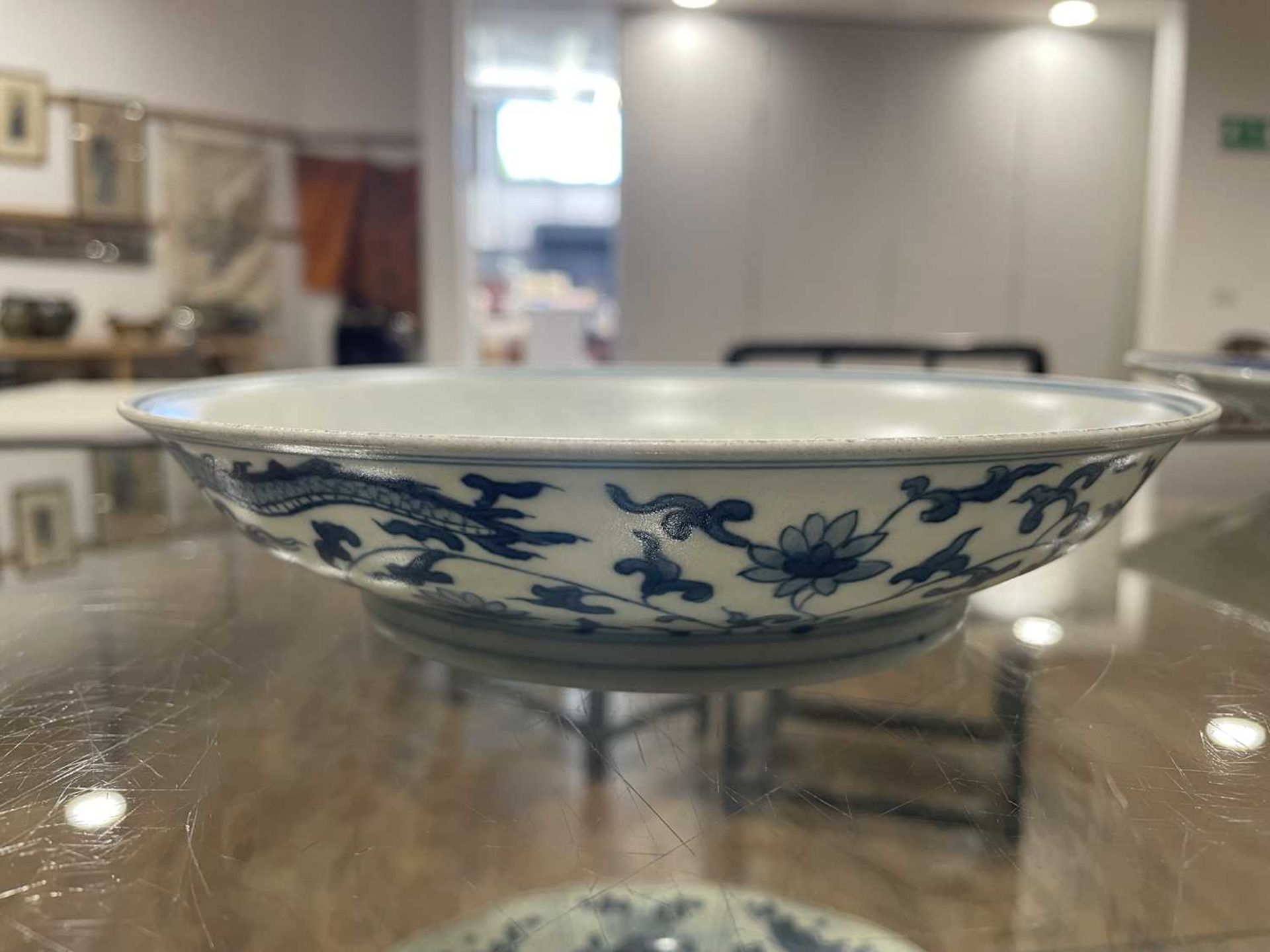A Chinese blue and white shallow dish, centrally decorated with a dragon and lotus flowers, pseudo - Image 19 of 31