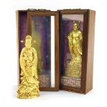 A pair of Chinese gilt decorated cast metal figures, each modelled as a scholar and contained in a