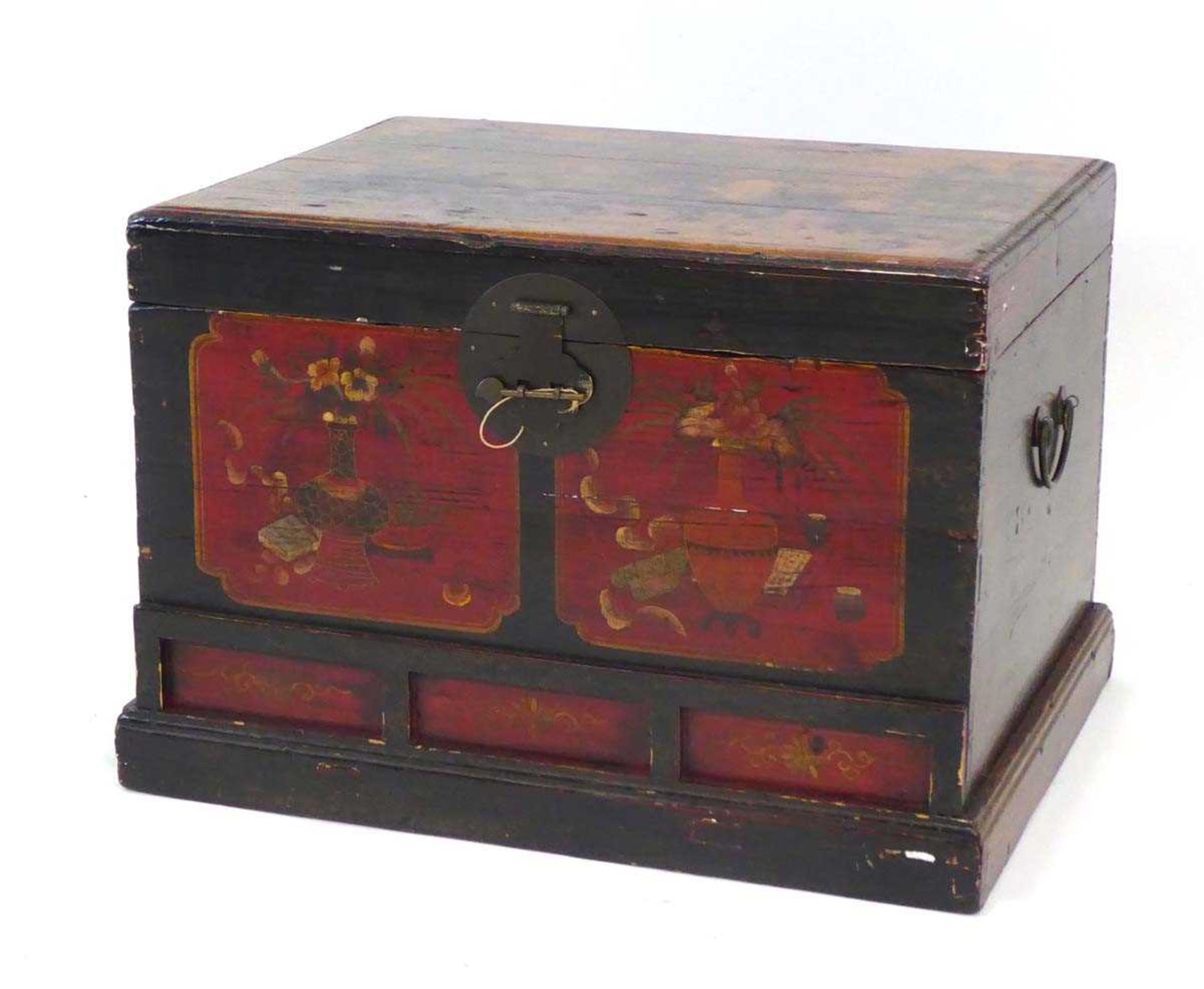 A Chinese lacquered pine chest, the lid opening to reveal a vacant interior, over three faux