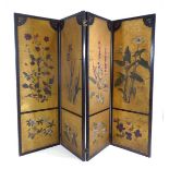 A Japanese four section screen, each panel gilt decorated with floral sprays within a black