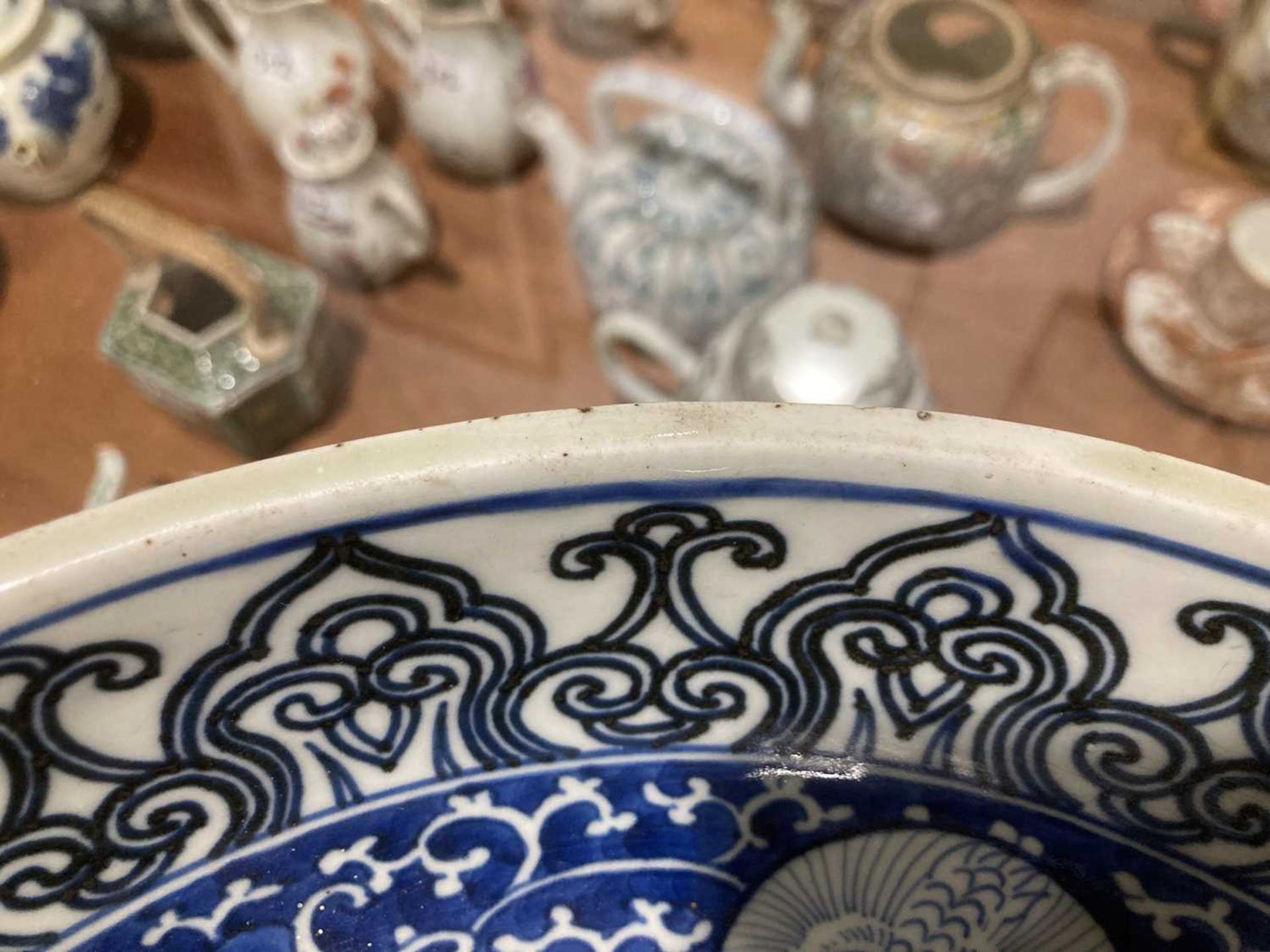 A Japanese blue and white bowl, centrally decorated with a shrubs within a scrolled border, - Bild 10 aus 12