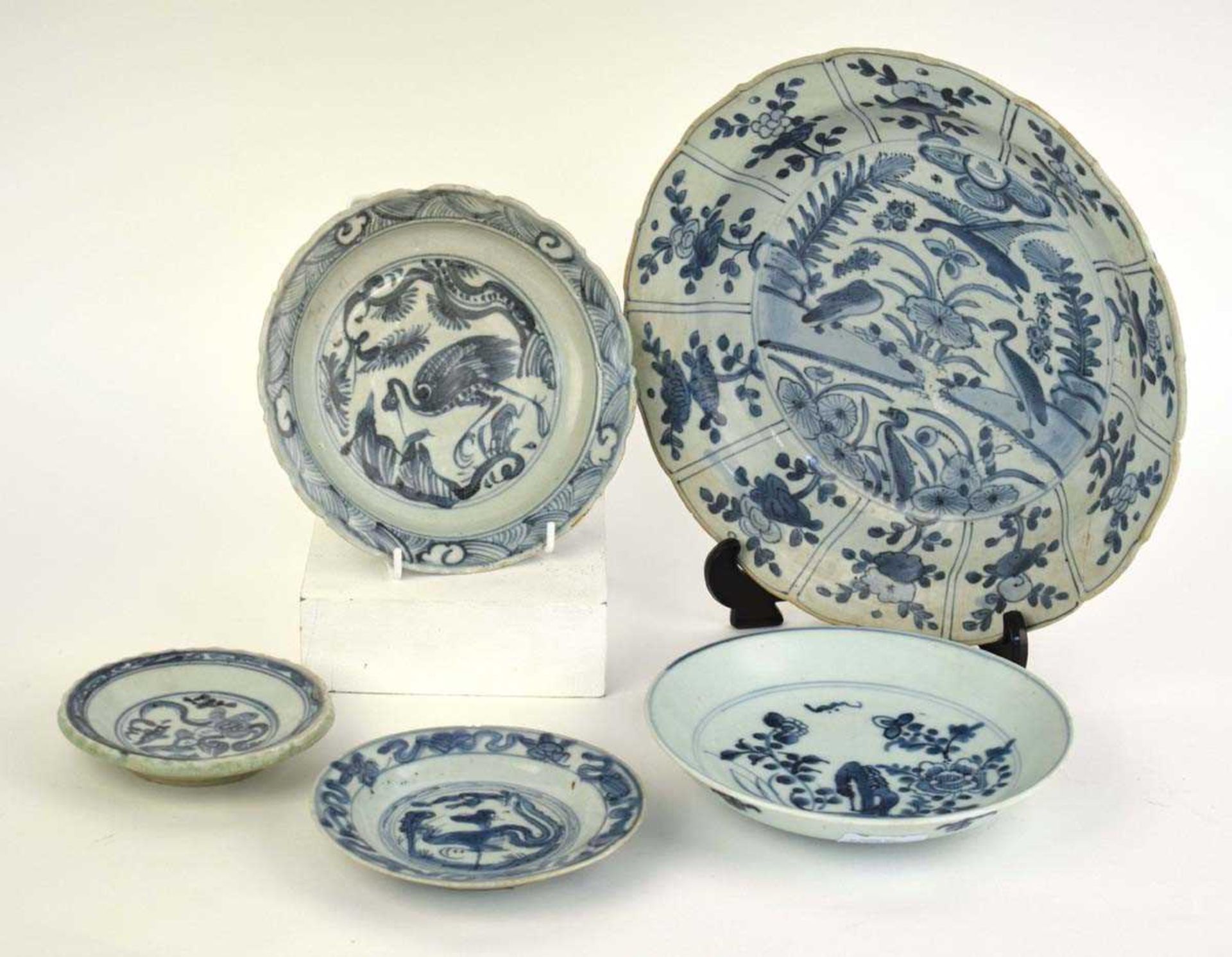 A Chinese blue and white shallow bowl of flowerhead form decorated with birds within foliate