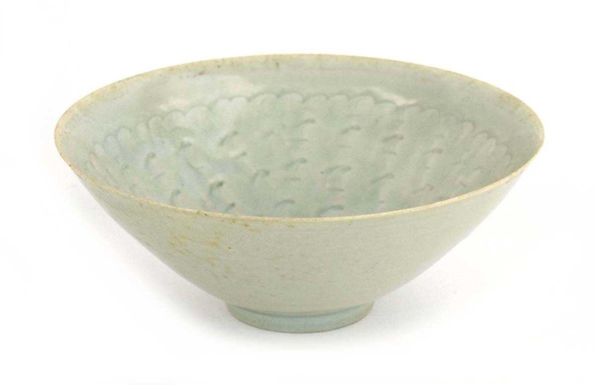 A Chinese celadon bowl of flared circular form, relief decorated with cloud like motifs, d. 20.5 cm,