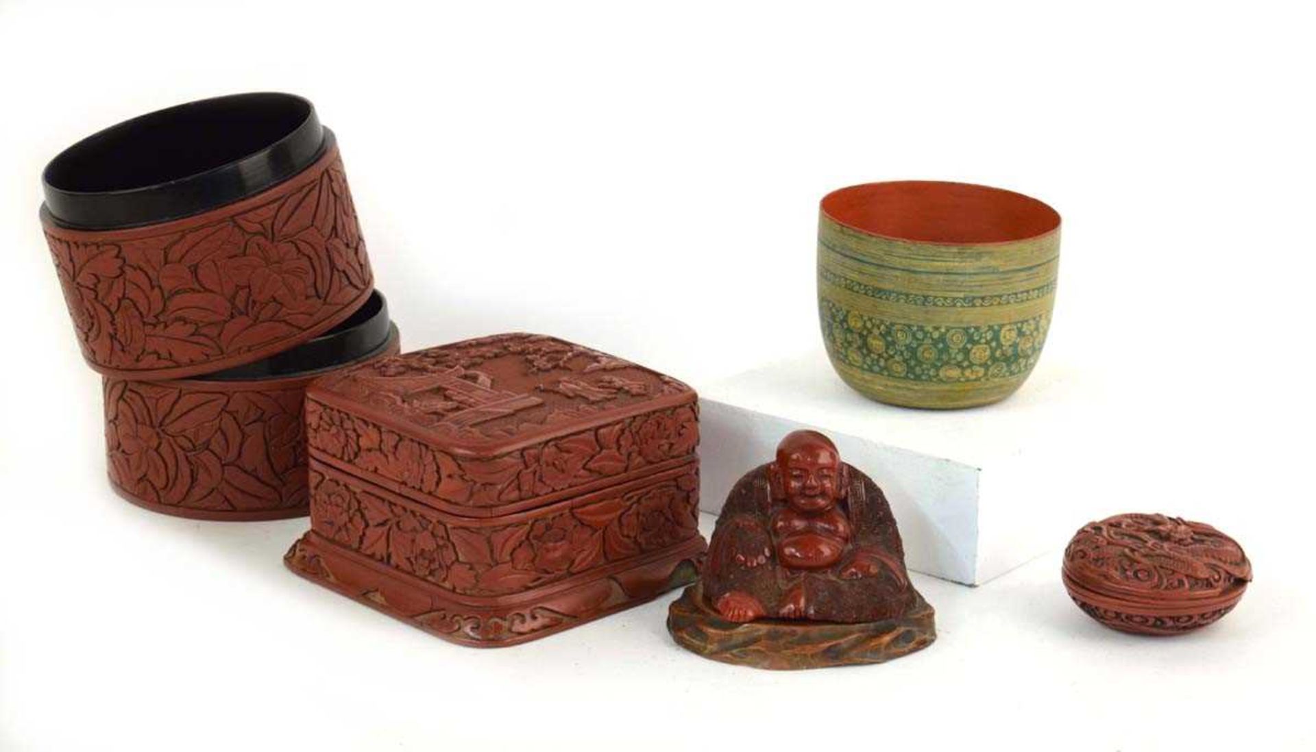A Chinese cinnabar lacquer-type figure modelled as the seated Buddha on a hardwood stand, h. 75