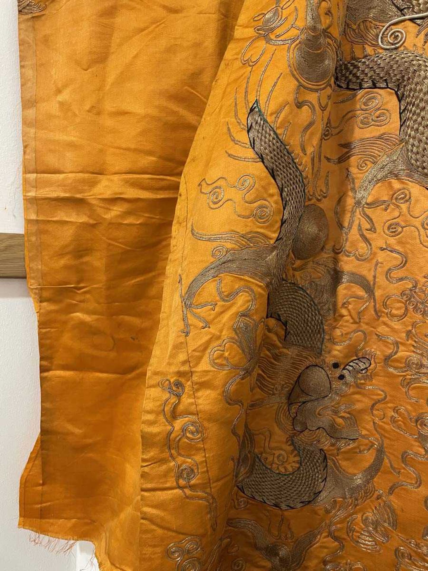 A Chinese robe section worked in gold coloured threads depicting dragons and a pagoda on an orange - Bild 6 aus 15