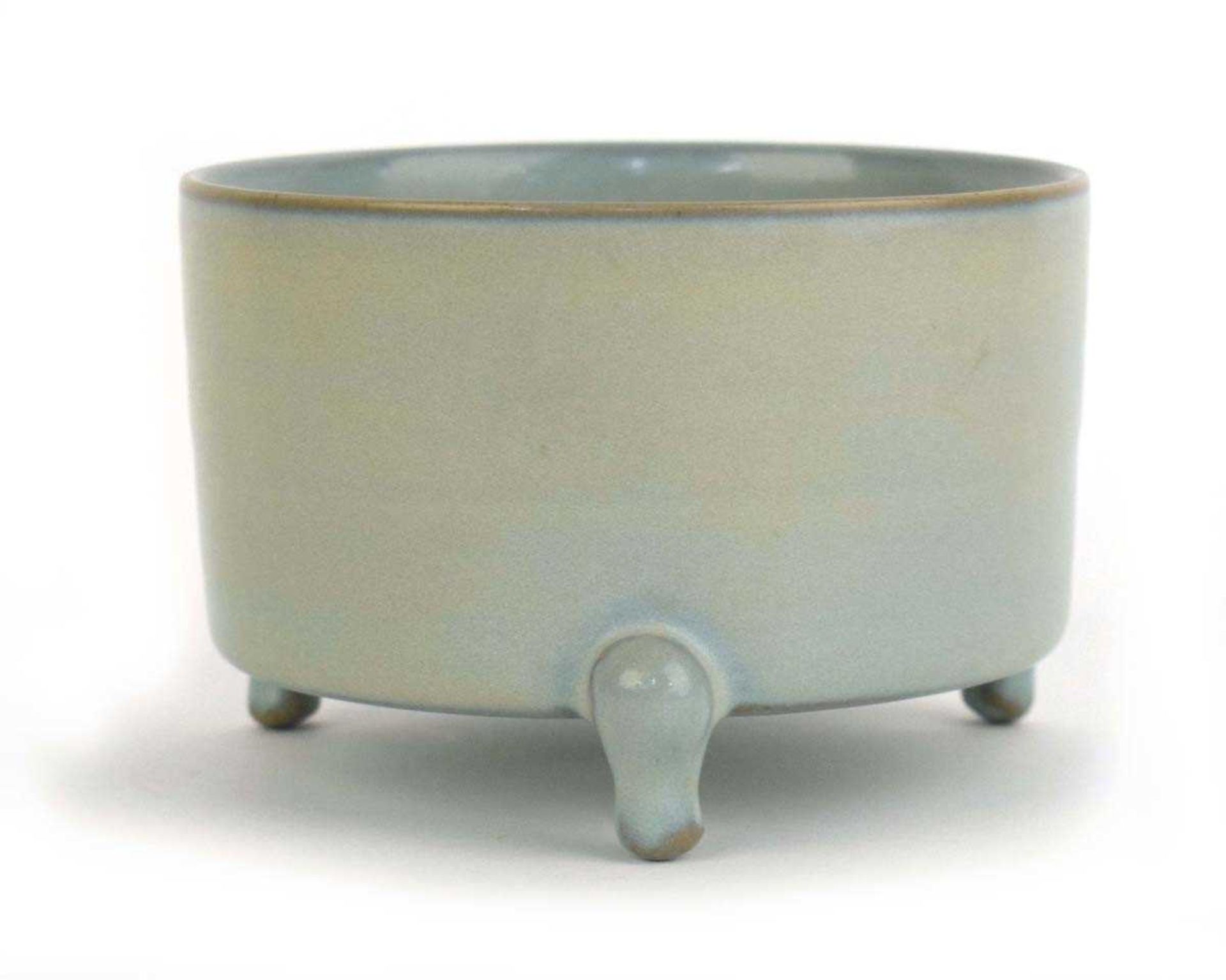 A Chinese celadon incense burner of plain circular form on three outswept feet, h. 9 cm, di. 13