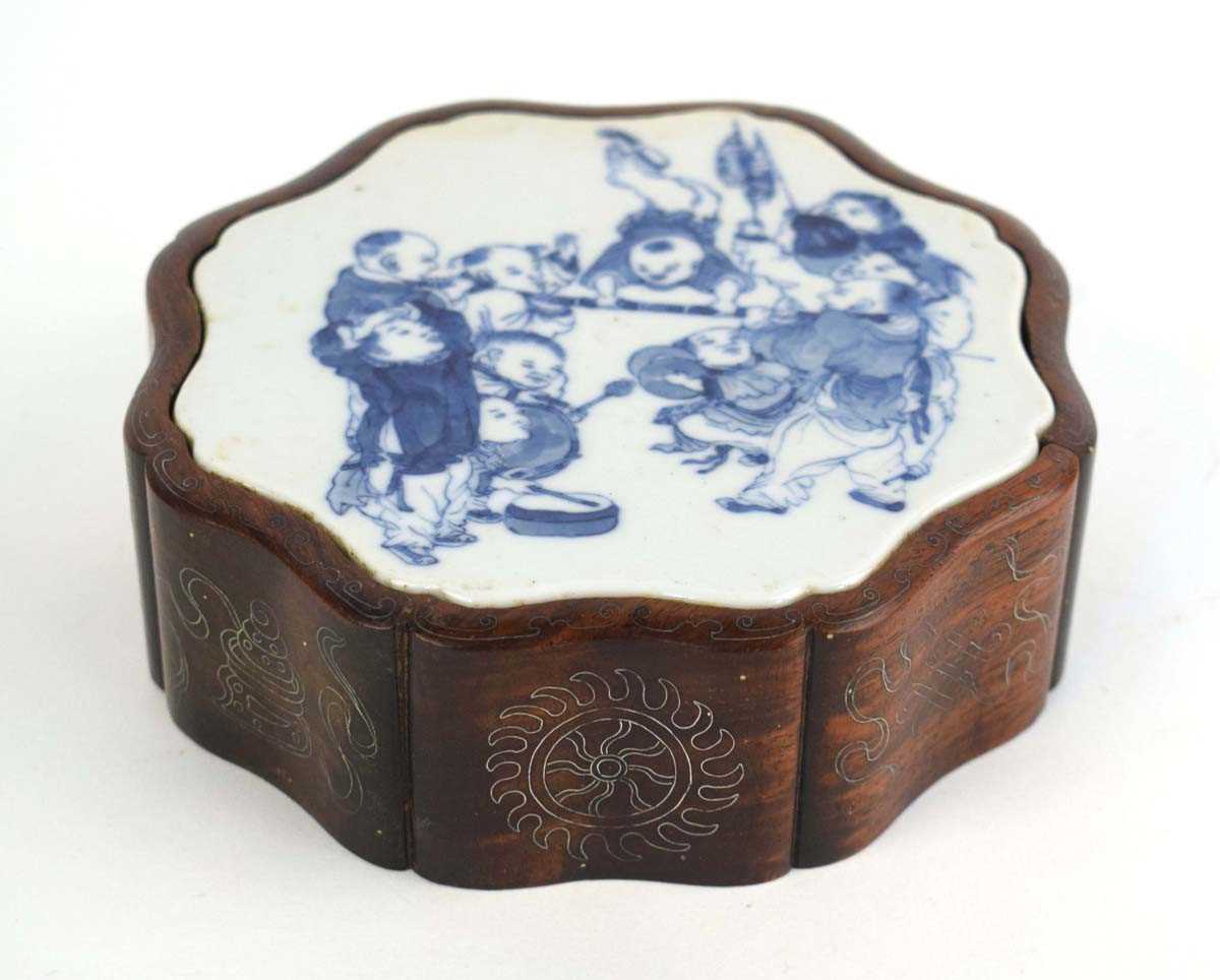 A Chinese blue and white plaque of flowerhead form decorated with children at play, set into a