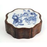 A Chinese blue and white plaque of flowerhead form decorated with children at play, set into a