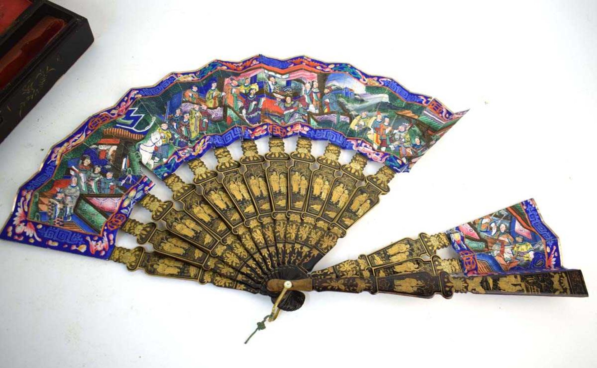 A Chinese lacquer work fan decorated with an extensive court scene, l, 28 cm when closed, w. 48.5 cm - Image 4 of 5