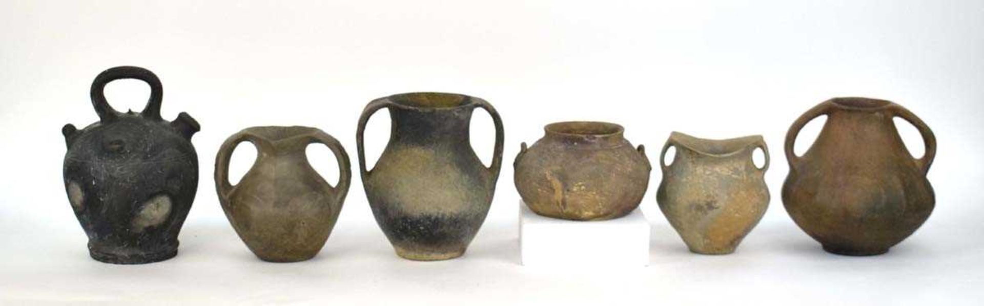 A Chinese archaic pottery two handled vase of squat form, h. 18 cm, together with five similar vases