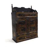 A Chinese lacquered table cabinet, gilt decorated with animals and traditional landscapes opening to