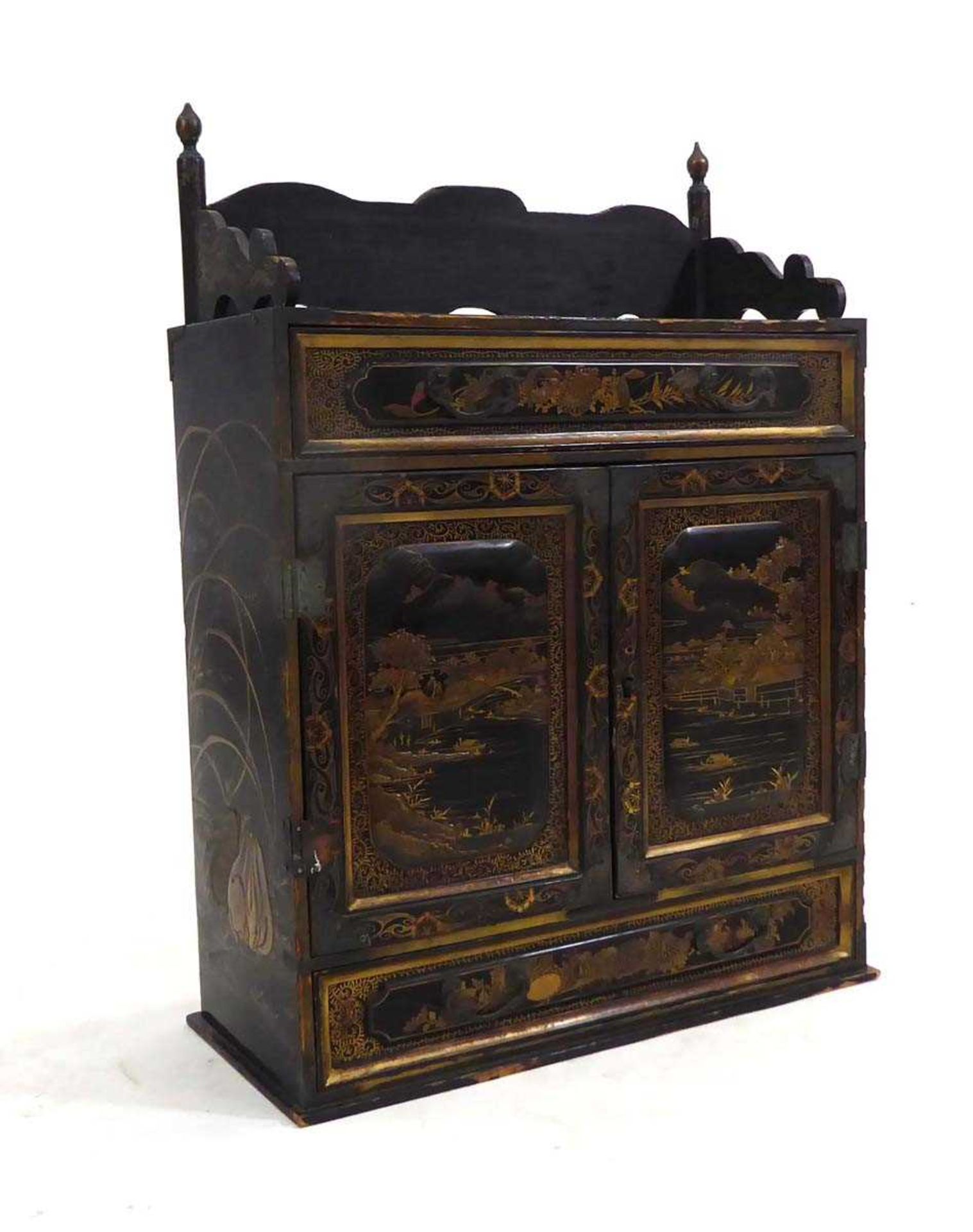 A Chinese lacquered table cabinet, gilt decorated with animals and traditional landscapes opening to