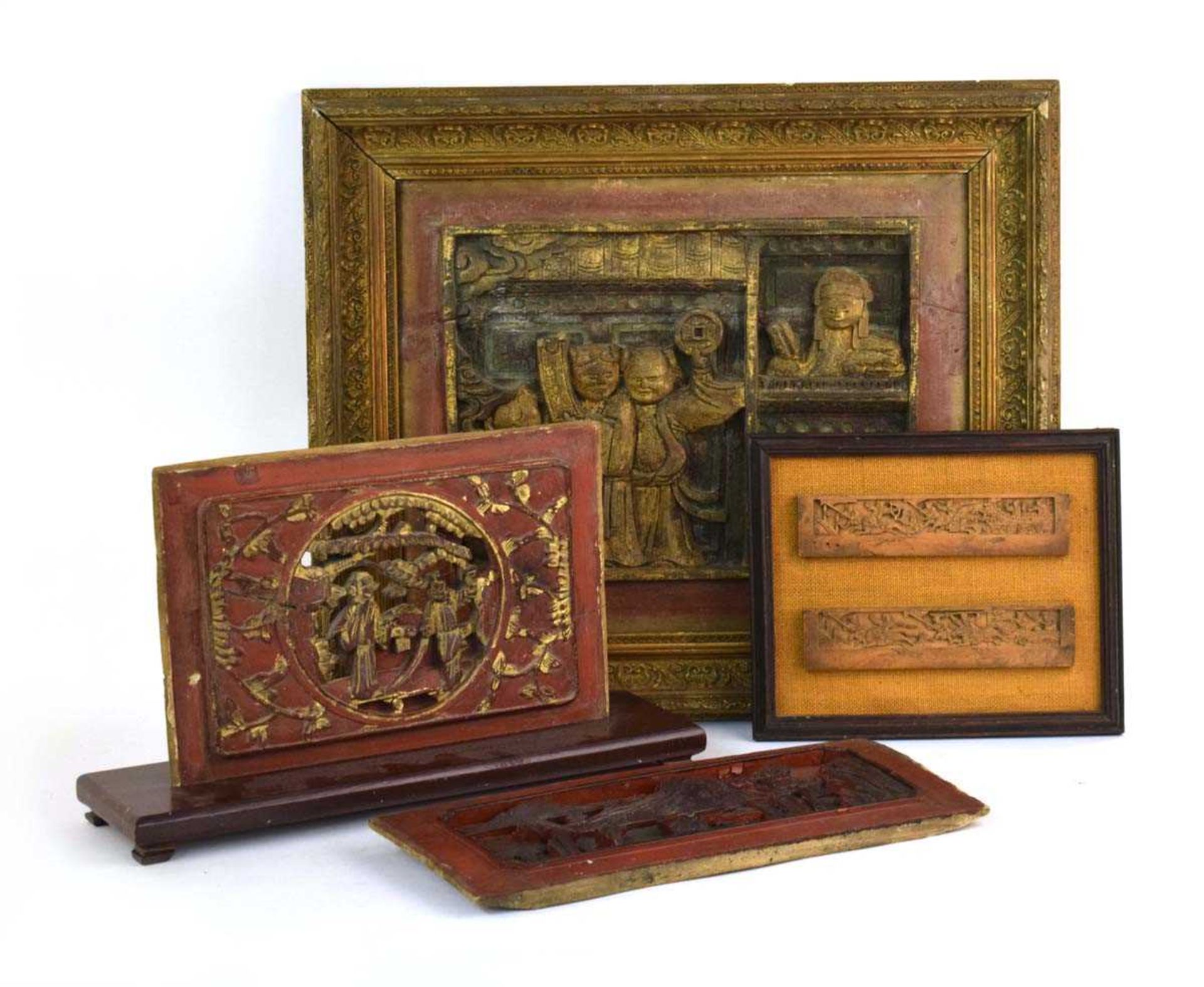 A pair of carved Chinese fruitwood panels, each modelled as a battle scene, frame 28 x 22.5 cm,
