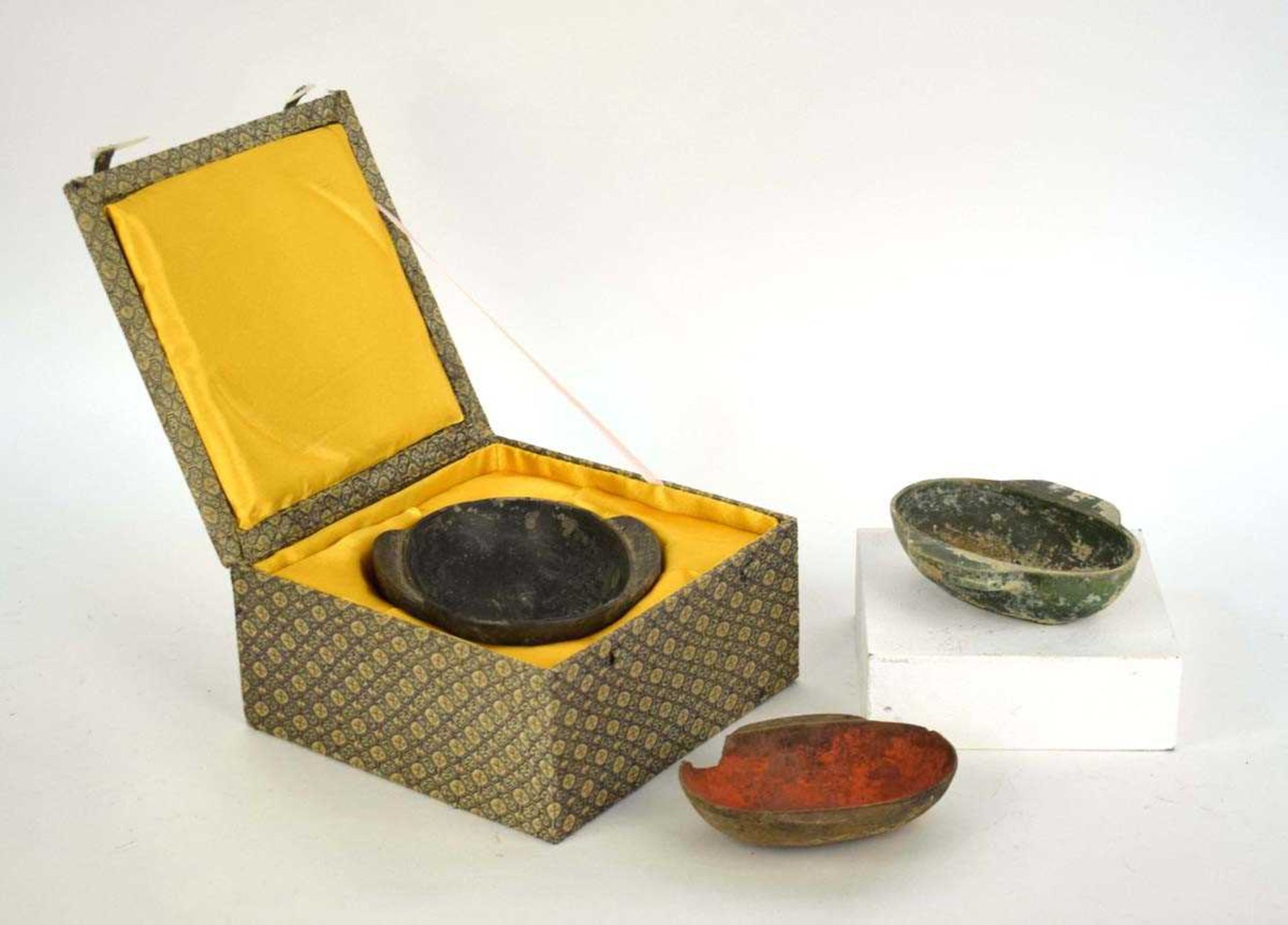 A Chinese archaic pottery ear cup decorated in a black glaze, l. 18 cm, boxed, together with two