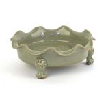 A Chinese celadon dish of scalloped circular form, relief decorated with exotic birds on three