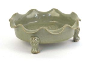 A Chinese celadon dish of scalloped circular form, relief decorated with exotic birds on three