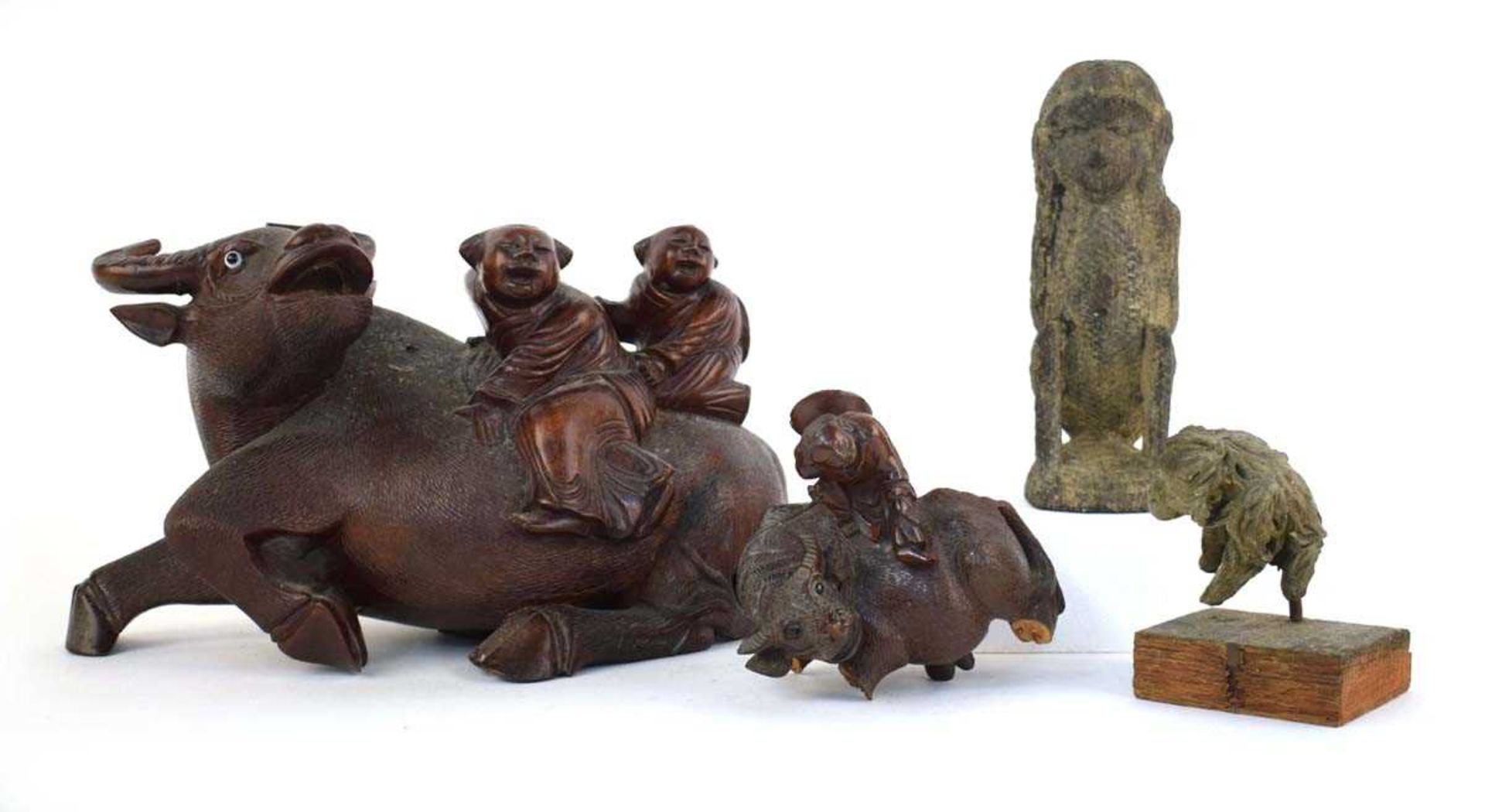 A Chinese carved hardwood figure modelled as a water buffalo and its riders, h. 17.5 cm, together