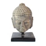 A stoneware figure modelled as the Buddhas head, h. 38.5 cm, including stand *from the collection of