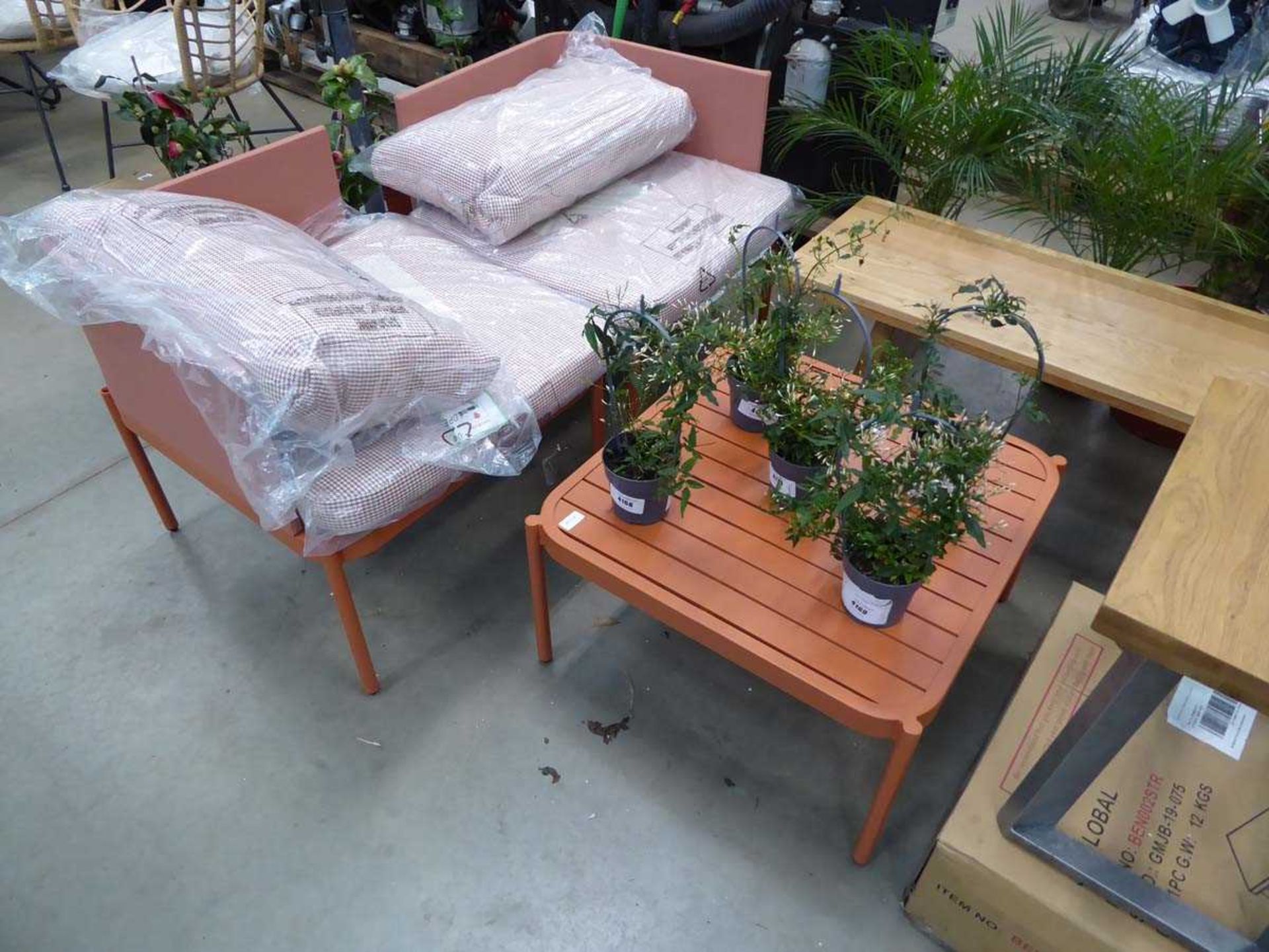 2 orange garden seats which make a bench and square metal table