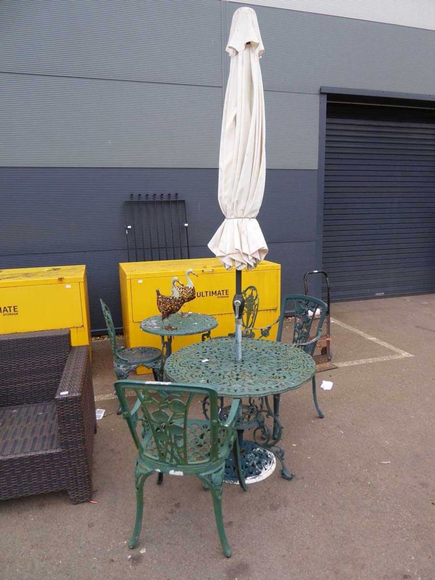 Large round metal garden table with parasol base and two chairs