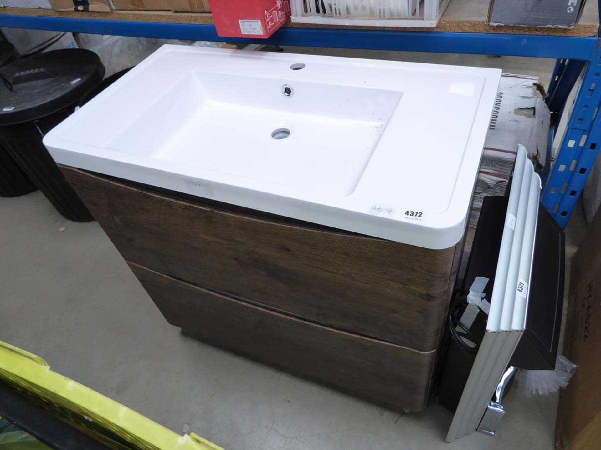 Dark wooden drawered vanity unit with sink above
