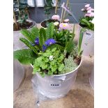 Pink metal pot containing assorted flower arrangement